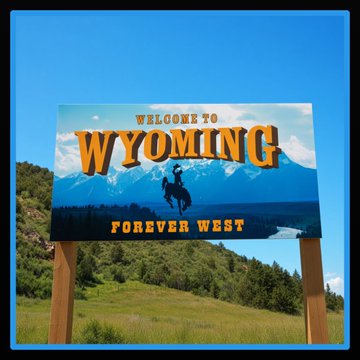 A "Welcome to Wyoming – Forever West" road sign stands against a backdrop of mountains and blue sky, symbolizing the state's bold frontier spirit. This image visually reinforces the post's announcement about Wyoming's Frontier Stable Token ($FRNT) transitioning its cross-chain infrastructure to Chainlink CCIP.