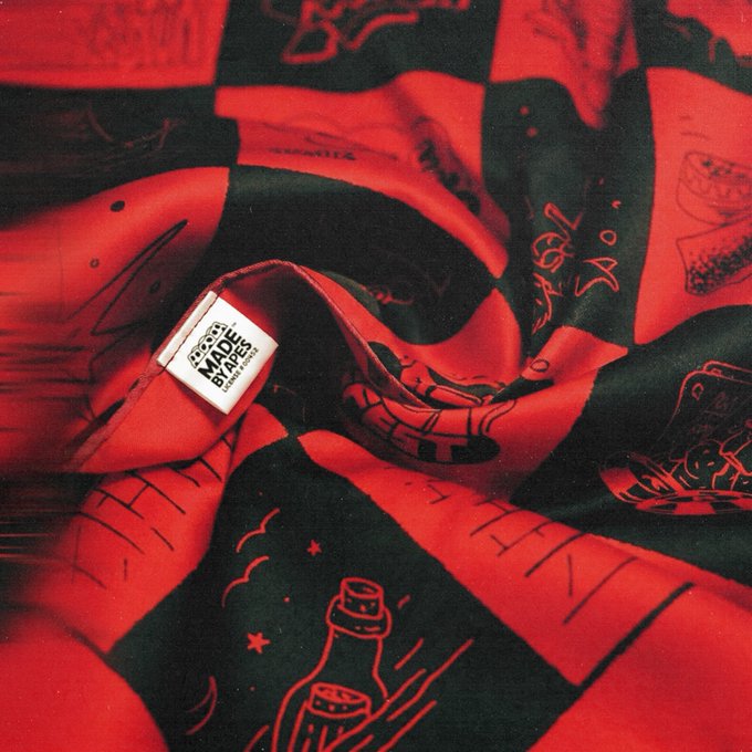 A crumpled red and black checkered bandana featuring illustrated bottle motifs and stars is displayed with a white "Made by Apes" label visible at the center, tying into the post's promotion of the limited-edition 26-piece "Made by Pauser" collection for ApeFest 2026.