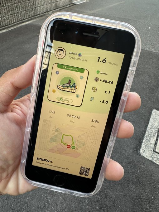The image shows a person holding up their phone displaying an app that tracks steps taken, calories burned, and distance traveled. The phone case has a picture of a cartoon character on it.