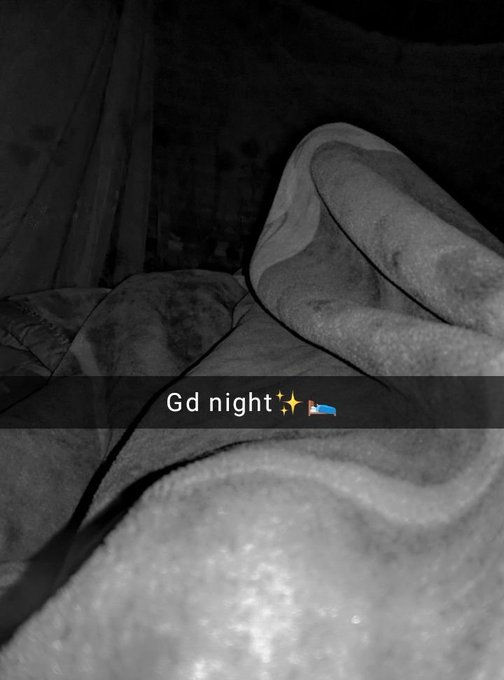 A black and white nighttime photo of someone bundled in a blanket, with text reading 'Gd night✨🛌'.