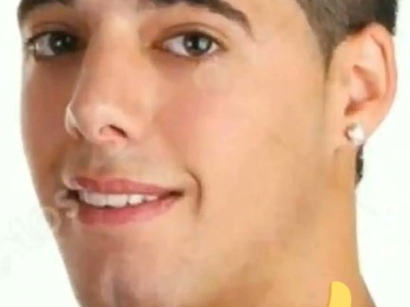 The image features a close-up of a man's face, with his eyes looking directly at the camera. He has short hair and is wearing earrings. There are two yellow objects in the background that appear to be related to the post #Cordano.