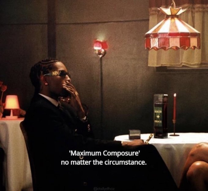 A stylish man in a dark suit and gold sunglasses sits at a table with a bottle and lit candle under a stained-glass lamp, with text reading ''Maximum Composure' no matter the circumstance.' and credit '@kolllytheboz'.