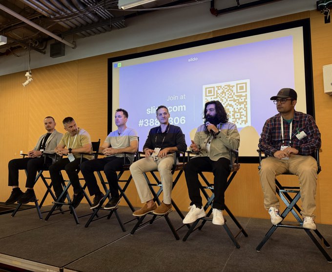 Six panelists sit on stage at the Google Web3 AI Summit, with the presentation screen behind them displaying "Join at slido.com #3881306" alongside a QR code, as one panelist speaks into a microphone while others listen.