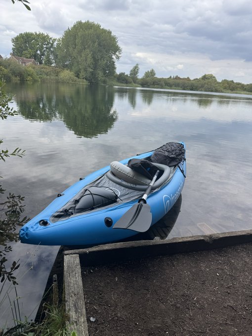 A blue inflatable kayak rests on a wooden platform beside a calm lake, with a paddle lying across its seat and a "Sevylor" logo visible on the side.

The image shows a peaceful outdoor scene by the water with a kayak, but it does not relate to the post's request for a coffee or crypto wallet comment—it appears to be an unrelated photo.