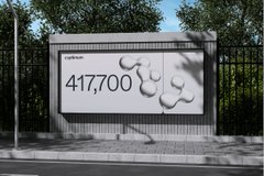 A video game screenshot showing a billboard or sign displaying "417,700" next to a creature design, set against an urban background with trees and a sidewalk.