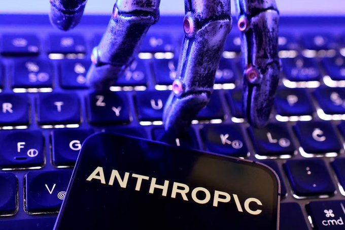 A skeletal robotic hand hovers menacingly over a keyboard behind a phone screen displaying "ANTHROPIC," visually symbolizing the AI company's rapid ascent in pre-IPO markets on Binance, where its theoretical valuation has surged 66-91% above its May private mark to between $1.6 and $1.84 trillion.