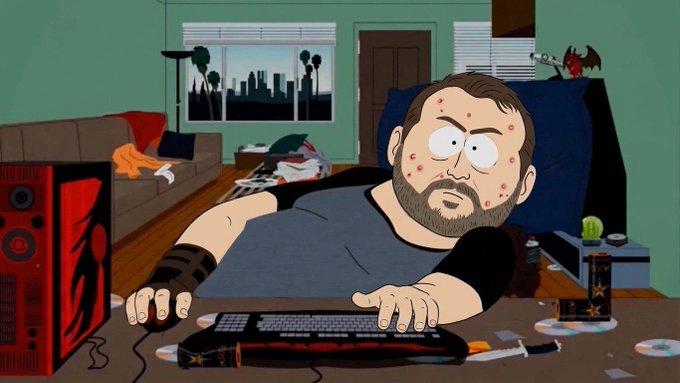 South Park animation of a bearded, acne-covered man sitting at a computer with a red dragon PC case, surrounded by a messy room with city skyline visible through the window.