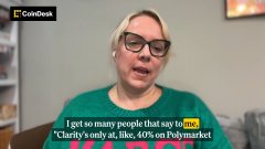 Coinbase Chief Legal Officer Kara Calvert, wearing a green shirt and earbuds, appears in a video interview with the on-screen text quoting her: "I get so many people that say the [crypto] CLARITY Act, 60% on Polymarket," referencing the market's optimism about the bill's passage, which aligns with Coinbase's claim that the legislation is close to becoming law.