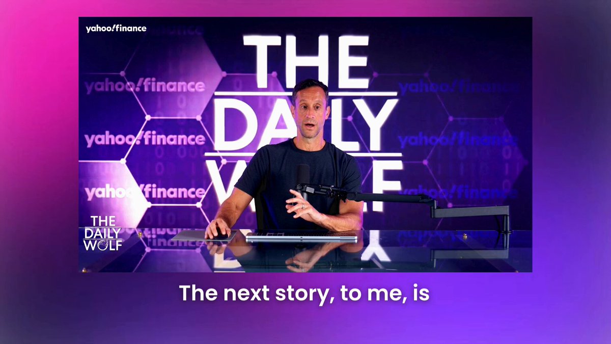 The image features a man sitting at a desk, wearing a black shirt and holding a microphone. The background of the image displays a purple and pink color scheme with various text elements such as "Yahoo Finance", "Daily Value", "The Daily Value", "ICE", "NYSE", "OKX", and "50-50 joint venture". This suggests that the man is giving a speech or presentation related to the Yahoo Finance, daily value, and ICE partnership.