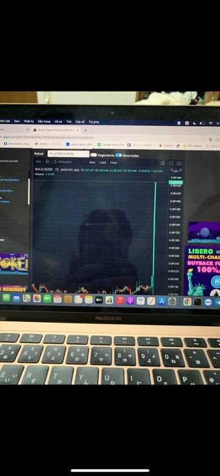 A MacBook Air laptop displaying a TradingView chart for the ticker 'MOCA/USD' with an uptrend visible, alongside other browser tabs.