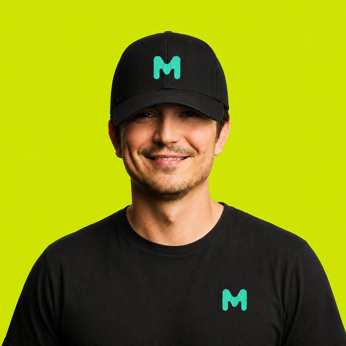 A smiling man wears a black cap and t-shirt featuring a green "M" logo, which represents mint.club—the platform mentioned in the post as stepping in to support the Robinhood chain following Noxa's unexpected outage.