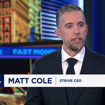 The image features a man wearing a suit jacket, sitting down and looking off into the distance with his head tilted slightly to the left side. The background of the picture shows a building, possibly a cityscape or an office building related to business news. The text on the image is about strategy news, specifically discussing the stock market, with the prices for SATA and STRC stocks being highlighted as well as their recent lows in relation to the market crash that occurred earlier this year.