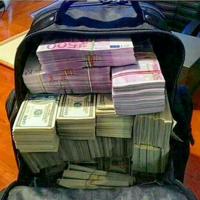 A suitcase is stuffed full of banded stacks of $100 US bills, with the post humorously suggesting this will be "Our bag in 2027" as an aspirational or exaggerated prediction of future wealth.