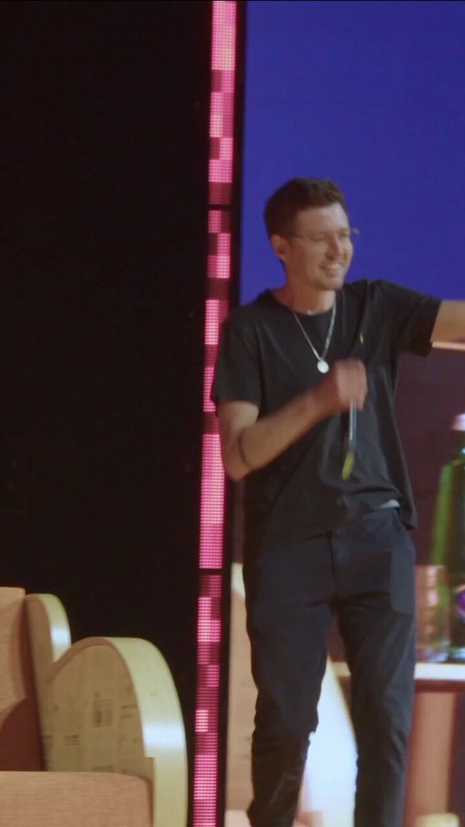 The image features a man standing in front of a stage with a podium behind him. The man appears to be giving a speech or presentation, as he holds a microphone in his hand. The background shows a large screen displaying the words "BTC Prague is back. Year four starts now." This suggests that the event might be related to cryptocurrency or digital currency and could potentially be an important announcement or launch for Bitcoin or another digital asset.