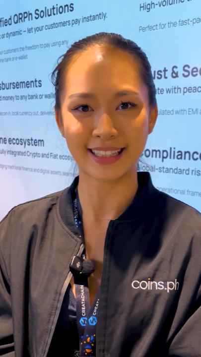 A smiling young woman wearing a black jacket with a lanyard, photographed in front of a backdrop advertising ORPh Solutions and crypto/Fiat ecosystems, with 'coins.ph' watermarked.