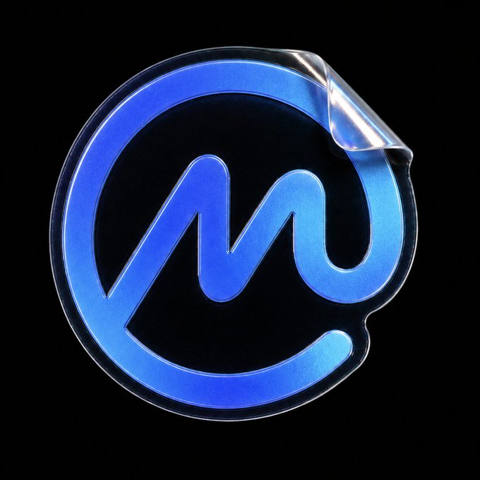 A glossy blue and black logo features a stylized lowercase "m" enclosed within a circular border, with a peeling effect on the top-right corner of the sticker-like design against a dark background.