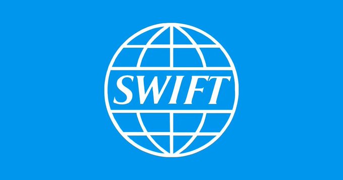The SWIFT logo, a globe with the word "SWIFT" inside, represents the organization that is launching a blockchain-based ledger for 24/7 cross-border payments. This new initiative aims to bring always-on settlement to its global network.
