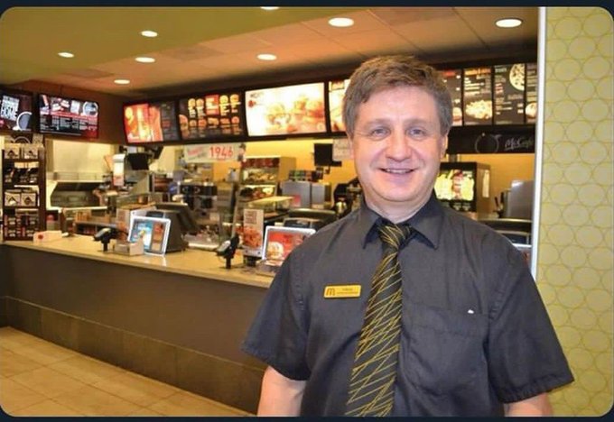 A smiling McDonald's employee wearing a name tag and a striped tie stands behind the counter, with a menu board visible in the background and a "1968" sign referencing the year McDonald's introduced the Big Mac.

The image relates to the post's "diamond hands" and "moon" language by featuring a man in a friendly service role—possibly a nod to meme culture, where McDonald's employees (like the "McDonald's Ice Cream Machine" meme) often become unlikely internet icons, with the man's confident smile playfully channeling the triumphant "to the moon" crypto/finance spirit.