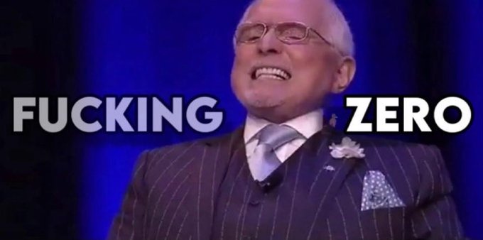 A photo of an older man in a pinstripe suit and glasses smiling widely, with bold overlaid text reading 'FUCKING ZERO' against a blue background.