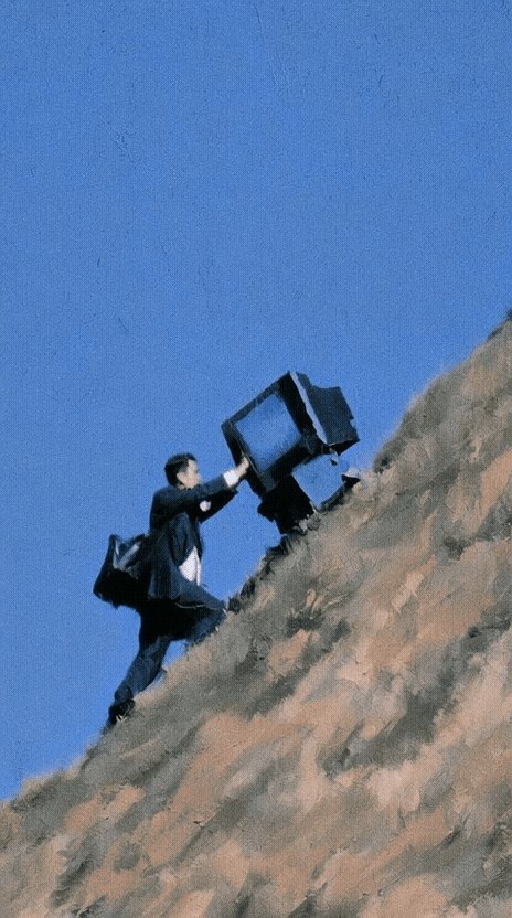 The image shows a man carrying two televisions up a steep hill, with one television being held by his left hand while the other is placed on top of him. The scene takes place against a blue sky background, which contrasts with the brownish-orange hue of the hill and the televisions. The post in question seems to be promoting Bitcoin or another cryptocurrency, as indicated by its title "Levels Sold from Hellloooa to DeltaSauce for 0.025Ξ opensea.io/item/ethereum/".