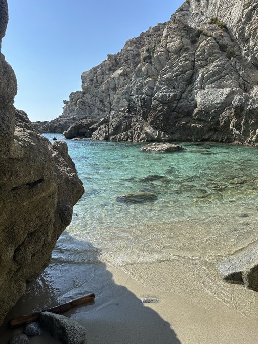 A serene, secluded cove with crystal-clear turquoise water nestled between rugged rocky cliffs, with no visible text or numbers in the scene—offering a quiet natural retreat that contrasts with the "waiting room" theme of the post.