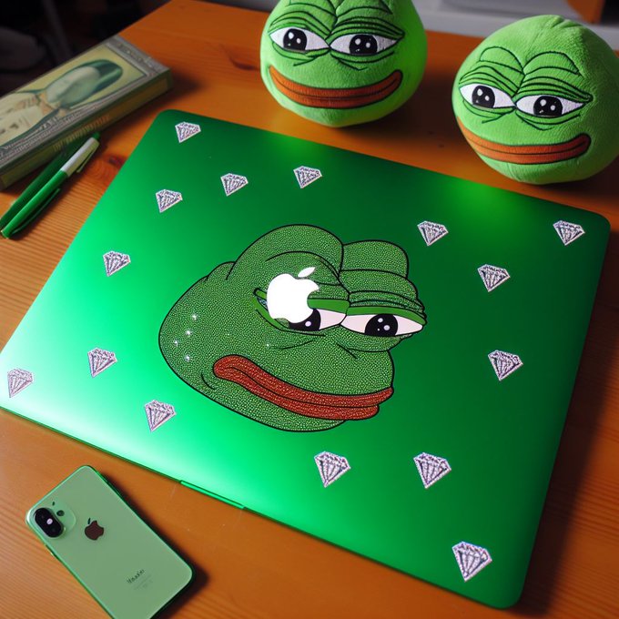 A green Apple laptop skin featuring the Pepe the Frog meme sits on a wooden desk, surrounded by matching Pepe plush toys, an iPhone with a green case, and dollar bills.