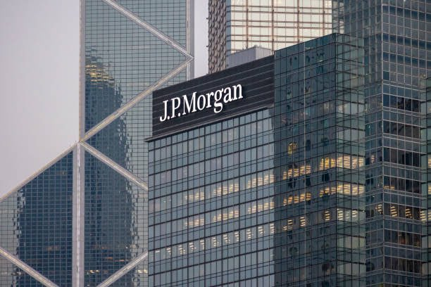 The image shows a tall building with the J.P. Morgan logo prominently displayed, indicating that the company has recently experienced significant growth or influx of funds. The building's reflection can be seen in its windows, suggesting that this skyscraper is located near other buildings as well. The text "$4 TRILLION JPMORGAN SAID BITCOIN AND CRYPTO INFLOWS TO SURGE BY OVER $130 BILLION THIS YEAR". This implies that the company has been involved in cryptocurrency trading and has experienced a surge in its value, which is reflected in the image.

The building's reflection can be seen on the windows of other buildings as well, indicating that this skyscraper is part of a larger urban landscape. The presence of multiple reflections suggests that there are many other structures nearby, possibly including more commercial or residential buildings.