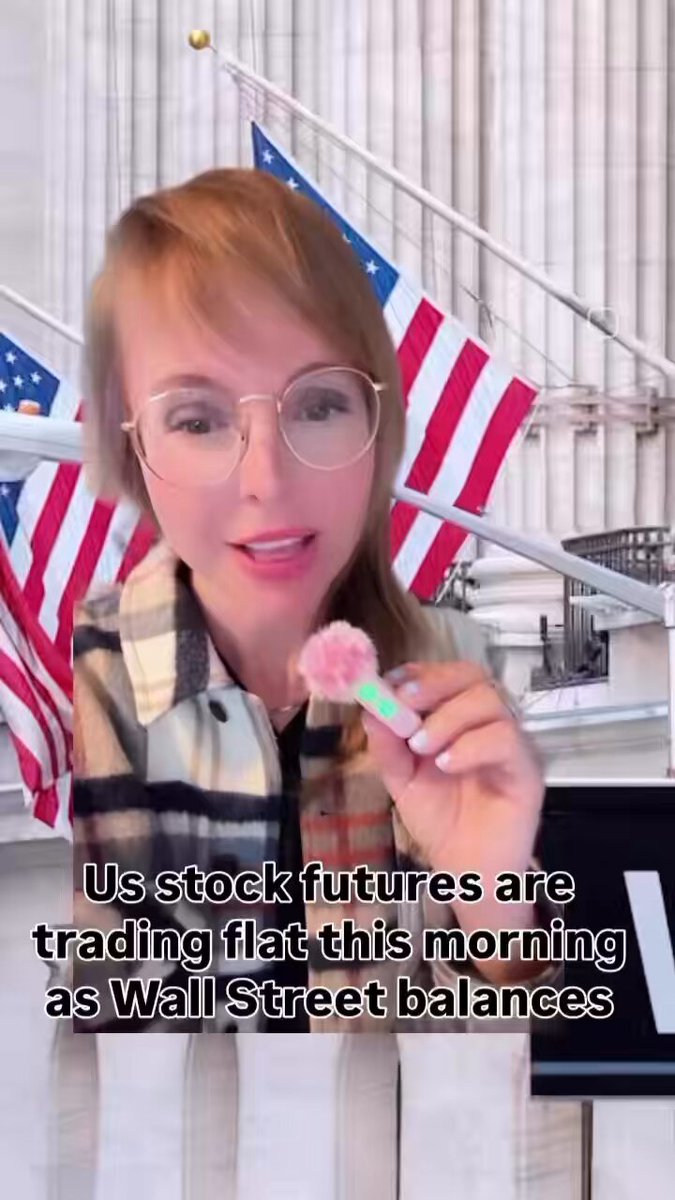 The image features a woman wearing glasses, holding a pink flower or candy in her hand while standing next to an American flag. The caption of the image reads "US stock futures are trading flat this morning as Wall Street balances". This suggests that there might be some financial news related to the stock market and its fluctuations. 

The post also mentions that the U.S. and Iran have reached a peace agreement, which could potentially impact the stock market. The caption implies that the woman is discussing these developments in her social media post or sharing information about them with others.