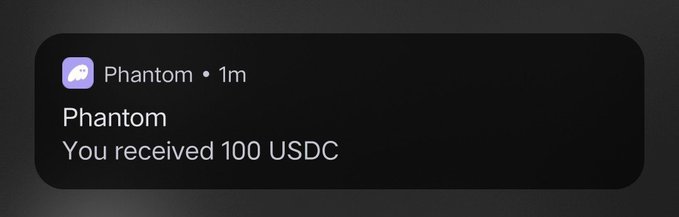 A notification from the Phantom crypto wallet reads "You received 100 USDC," which the post is humorously presenting as desirable free money ("notis") that followers might want for themselves.