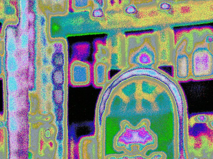 A heavily glitched, neon-soaked photograph of Tokyo's Taito Station in Shinjuku, with the image processing distorting the iconic Space Invaders-themed signage and architecture into a vibrant, pixelated mess of pink, green, and yellow hues. The glitch effect emphasizes the retro gaming aesthetic of the location, aligning perfectly with the "#glitchphotography" and "#spaceinvaders" themes mentioned in the post.