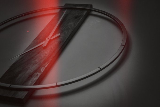 A modern artistic wall clock with a dark wooden central plank and thin metal ring, featuring red laser-like light beams creating a dramatic effect against a dark background.