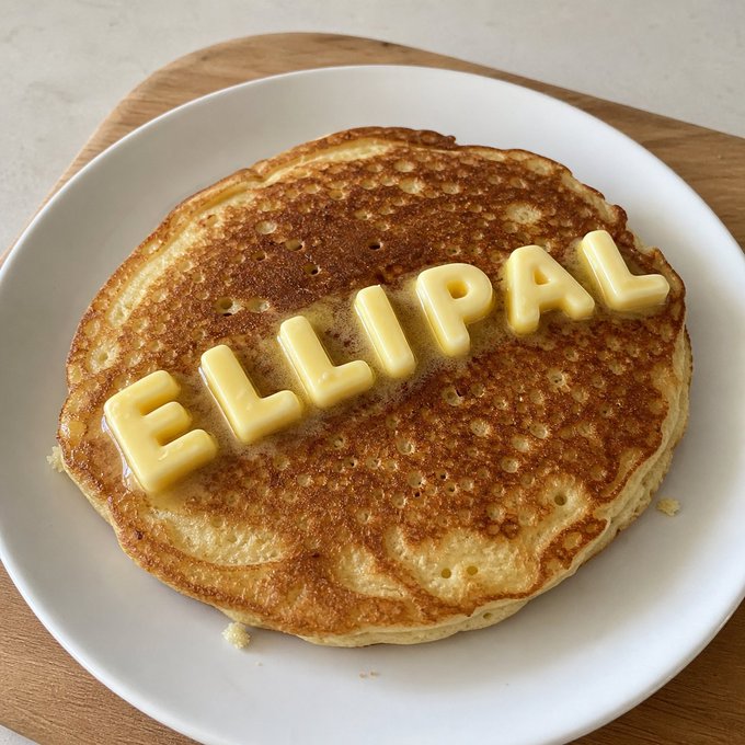 A golden pancake topped with butter pats spelling out "ELLIPAL" sits on a white plate, playfully tying the wallet brand name to a leisurely weekend breakfast away from the screens.