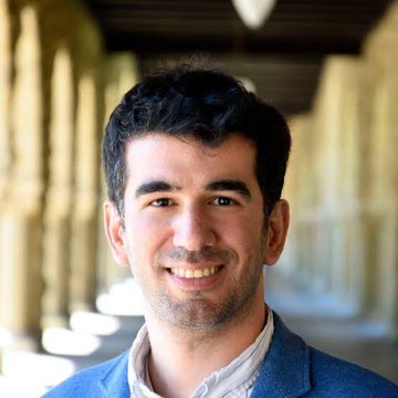 A smiling man with dark hair and a blue jacket stands in what appears to be an arched colonnade, likely a Stanford campus setting. The image accompanies a post comparing Pi Network founders—Stanford PhDs Dr. Nicolas Kokkalis and Dr. Chengdiao Fan—to SCALE Network founders Chris Parker and Alex Morgan, highlighting the academic and tech pedigree behind both crypto ventures.