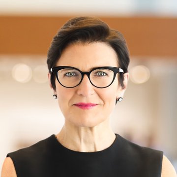 A portrait of a woman with short dark hair, black-framed glasses, and pink lipstick, wearing a black sleeveless top, which appears to depict Citi CEO Jane Fraser amid her recent comments on the bank's role in digital assets and supportive stance on crypto regulation.