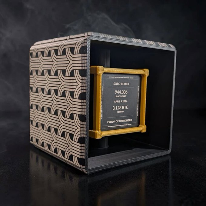 A physical Bitcoin 'Solo Block' commemorative coin dated April 9, 2024, displayed in a decorative woven wooden display case, marking block height 944,306.