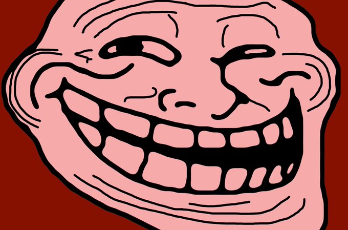A cartoon troll face with a wide, toothy grin is displayed against a dark red background. The image visually represents the "$TROLL" cryptocurrency ticker mentioned in the post, using the classic "trollface" meme as a playful symbol of the coin's ironic, meme-driven appeal.