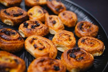 A tray of golden-brown sausage rolls arranged for serving, perfect as a hearty breakfast option for attendees waiting for judging to begin.
