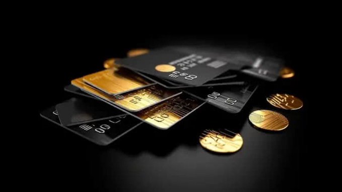 The image features a stack of gold credit cards, with some coins placed around them. The cards are arranged in a way that they appear to be sitting on top of each other or stacked up against one another. The coins are scattered around the cards, adding an interesting visual element to the scene. The post appears to be discussing the benefits and features of these gold credit cards, possibly highlighting their value or design.