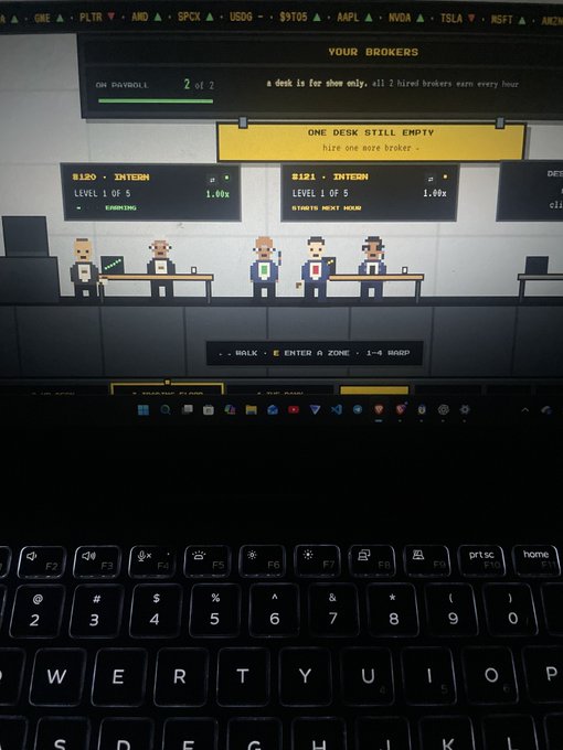 A laptop screen displaying a pixel-art broker simulation game titled 'YOUR BROKERS' with stock tickers like GME, PLTR, AMD, SPCX, USOG, TSM, AAPL, NVDA, and TSLA at the top. The pixelated character broker stands at a desk with text reading 'ONE DESK STILL EMPTY - hire one more broker -' and keyboard controls (WALK, ENTER, ZONE, HANDP) shown below.