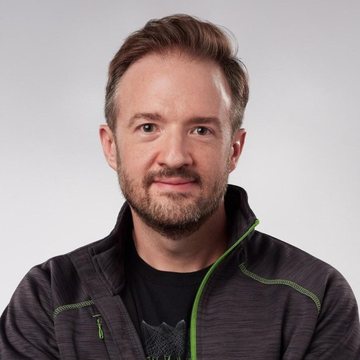 The image features a man with a beard wearing a black jacket against a white background. The man has his arms crossed, giving off an air of confidence or authority. There are no texts present in the image, so we cannot determine if there is any information about the post or its content.