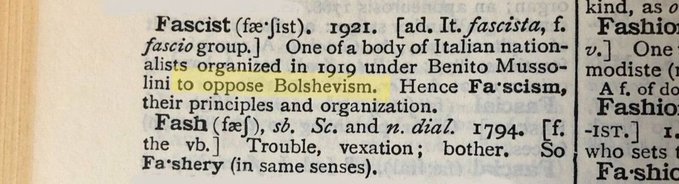 A close-up of a dictionary page defining 'Fascist' as 'One of a body of Italian nationalists organized in 1919 under Benito Mussolini to oppose Bolshevism', with the phrase 'to oppose Bolshevism' highlighted in yellow.