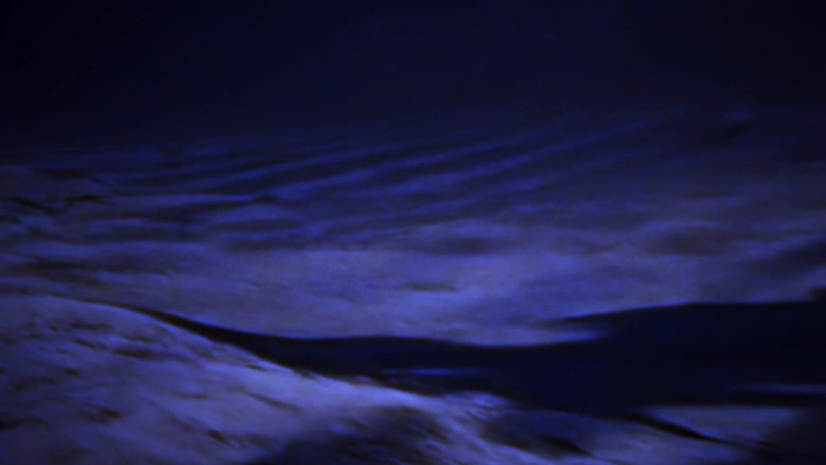 The image shows a dark blue sky with white clouds, giving off an impression of a starry night or a cloudy day. The scene appears to be captured from below, looking up at the sky. There are no people or objects visible in the photo, but there is text present that reads "GUYS.....LISTEN TO THE VOICE ON THE @WhiteHouse POST THE VOICE SAYS $solana:FpBhnZLzHjgPtc69vkimPtHCwN4xoeX3RUhDa3Bpump". The focus of the image is on the sky, and there are no other objects or people in the frame.