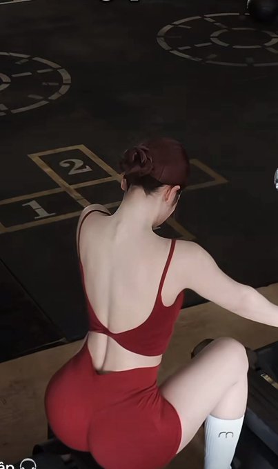 A woman in a red backless dress sits facing away from the camera, with numbered floor markings ("2" and "1") visible behind her. The image contrasts the calm, stationary pose of the woman with the post's description of market "sideway" action and anticipation of an FOMC hold, mirroring the stillness before the Fed's policy decision.