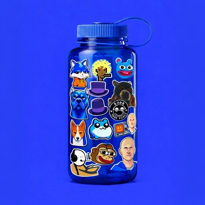 A translucent blue Nalgene-style water bottle is covered in an assortment of colorful stickers, including a FOX logo, a "SORB" milk carton logo, cartoon cats, dogs, a monkey, and characters from *Back to the Future*. The post's "Drop your favorite ticker" prompt ties into the bottle's sticker-covered design, inviting viewers to share their own sticker/ticker preferences just as the bottle displays a personal collection of favorite brands and mascots.