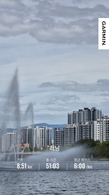 A Garmin running activity screenshot in Korean showing an 8.51 km run ('러닝') with a time of 51:03 and an average pace of 6:00 /km, overlaid on a photo of a waterfront with apartment buildings.