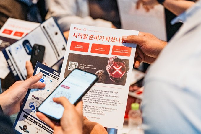 A close-up of hands holding promotional flyers, one prominently displaying Korean text '시작할 준비가 되셨나' and a 'Fire ONE ONE 8TH' graphic, alongside a smartphone screen.