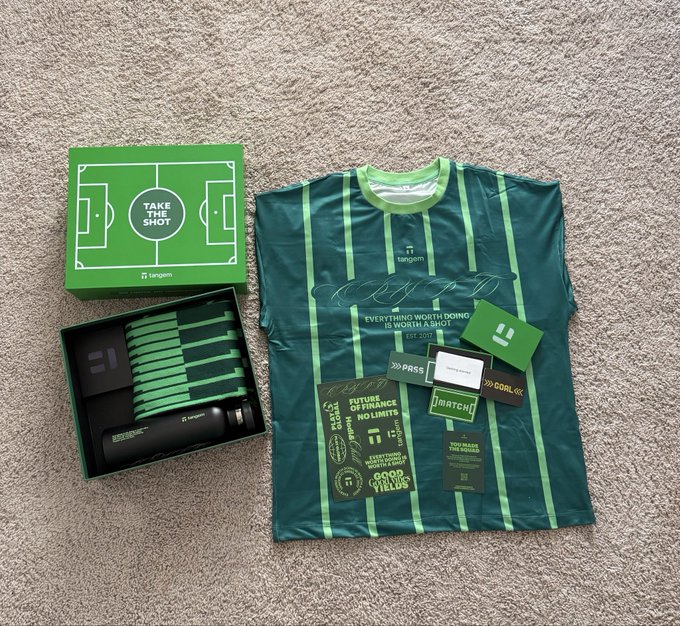 A green soccer-themed gift box labeled 'TAKE THE SHOT' by Tangem sits next to a matching striped jersey, a water bottle, and various cards including 'PRESS', 'MATCH', and 'GOOD LUCK'.