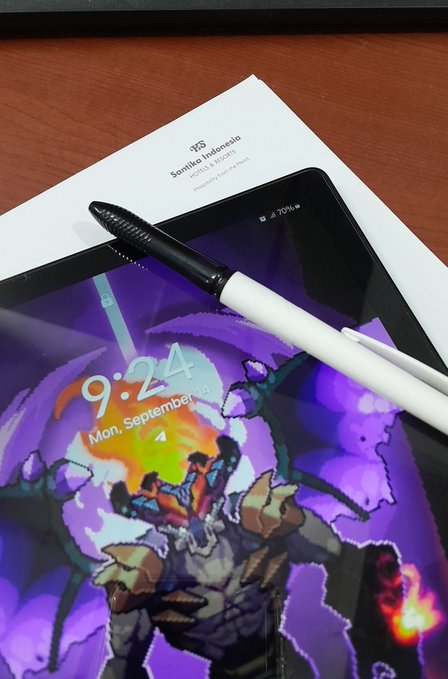 A black stylus rests on a tablet displaying a lock screen with the time '9:24' and date 'Mon, September', partially covering a book titled 'Senjaku Indonesia'.