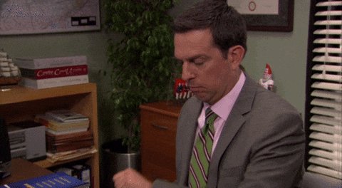 iced coffee on a desk, with a man in a suit and tie reading a book, surrounded by office supplies and plants.