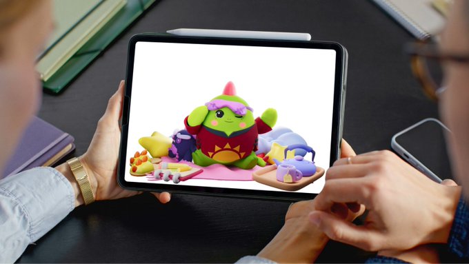 Two people looking at a tablet displaying a colorful clay sculpture of a character with a pink hat and purple eyebrows, surrounded by small play items.